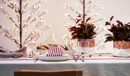 Festive table with linen tablecloth, striped napkins and tree lights