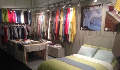 Linen textiles and bedding displayed at an exhibition stand