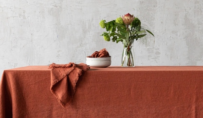 Autumn table set with a brick-red linen tablecloth and flowers