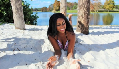 Woman relaxing on white sand beside a lake