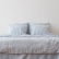 Blue Ticking Stripe linen bedding on a bed, front view