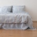 Close view of Blue Ticking Stripe linen bedding on a bed